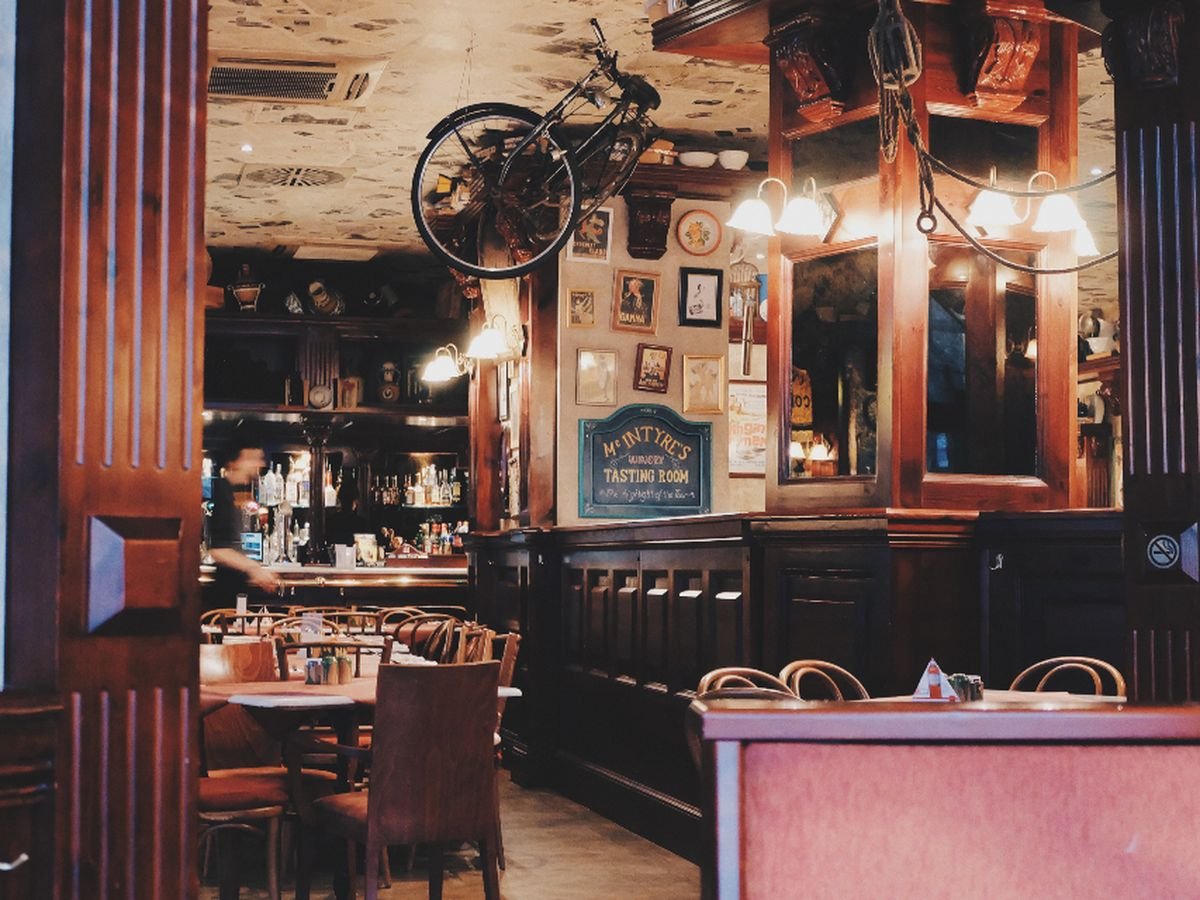 Brick walled cafe interior with wooden tables and warm pendant lighting