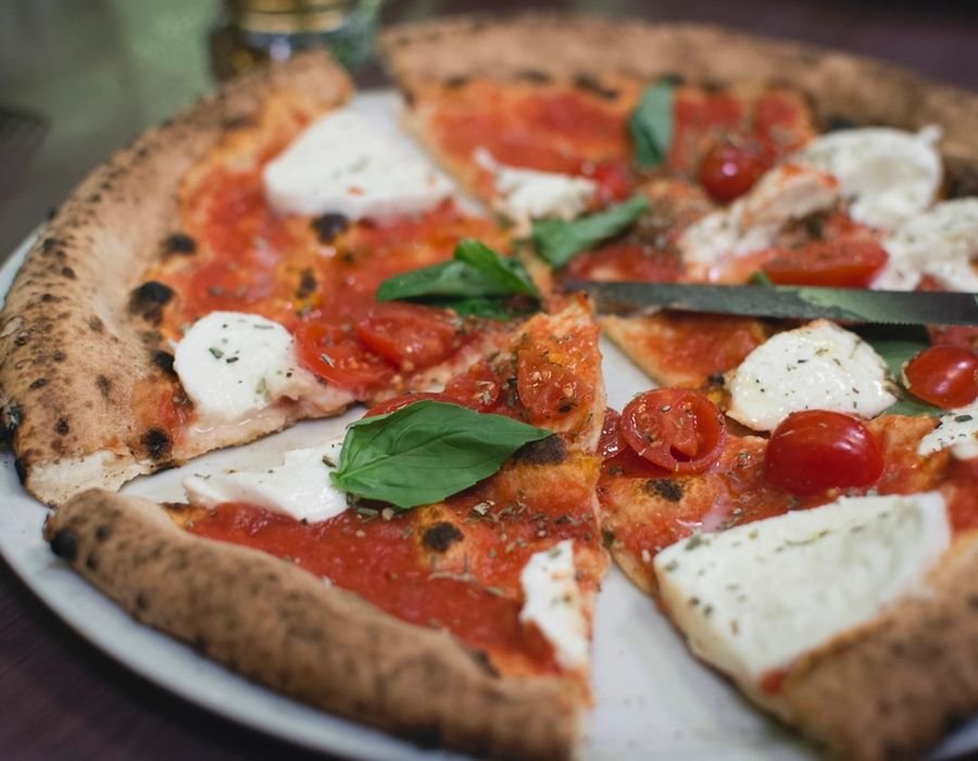 Thin crust margherita pizza with tomato, mozzarella and basil